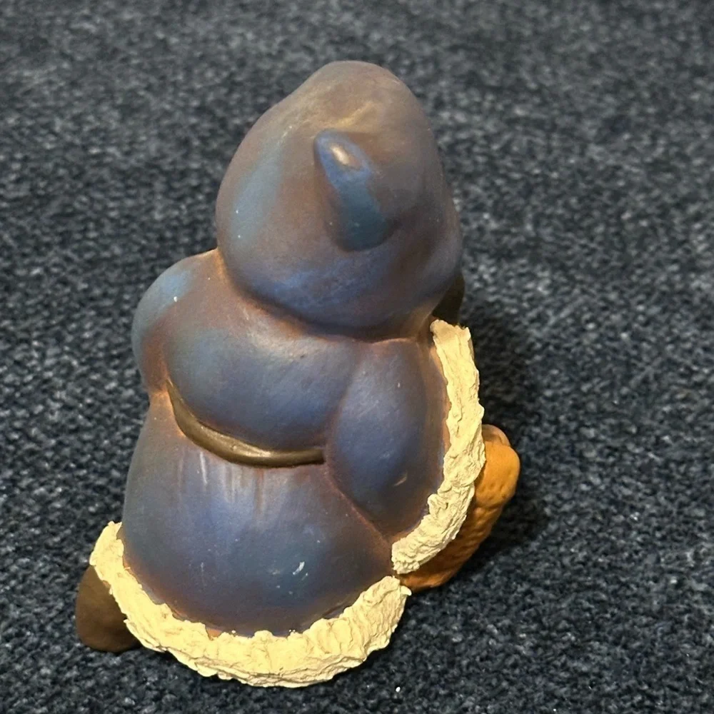 Cute blue robed kneeling Santa. He carries a basket of gifts.